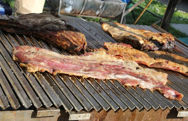 Carne grelhada em uma barraca de comida na rua com bacon e cozida — Fotografia de Stock