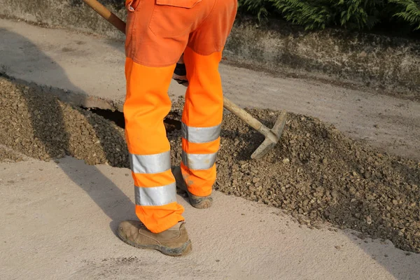 Mann mit orangefarbener Hose auf Baustelle am Werk — Stockfoto