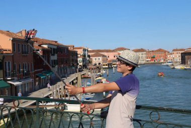 onun smartph tarafından bir fotoğraf çeker iken genç genç çocuk gülümsüyor