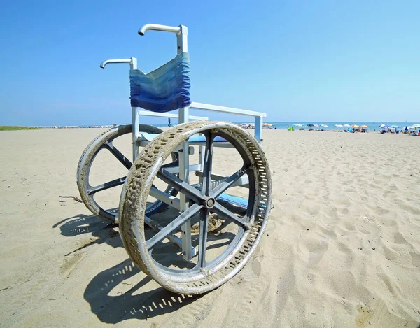 Инвалидное кресло с большими стальными колесами, чтобы идти на песок — стоковое фото