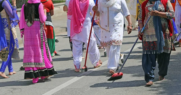 Sikh women while scavenging the street with a broom during a fes — Stock Photo, Image