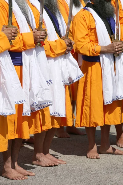 Barfüßige Männer in orangefarbener Kleidung feiern ein Sikh-Fest — Stockfoto