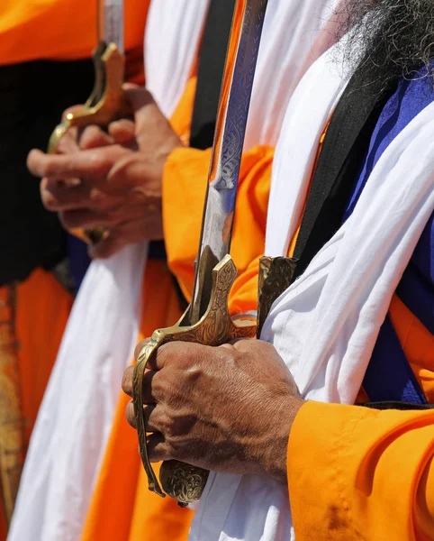 Rukou Sikh starší muže, kteří drží meč během náboženských f — Stock fotografie