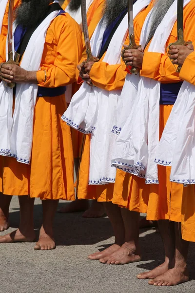 Kılıç druing bir Sih Festivali ile birçok yalınayak erkek — Stok fotoğraf