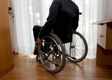 disabled person in his bedroom with a desk clipart