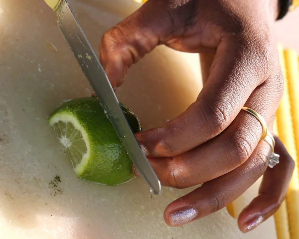 Hand with ring of the Brazilian girl that cut into slices lime — Stock Photo, Image