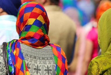 sikh women with multicolored veil during a religion ceremony clipart