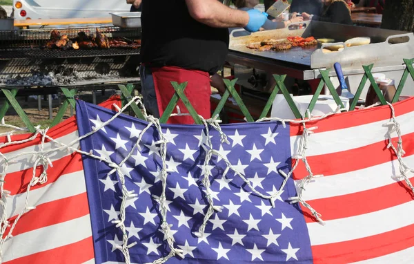 Bandeira americana na banca de comida de rua enquanto o cozinheiro — Fotografia de Stock