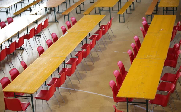 long table with red chairs in a wide classroom