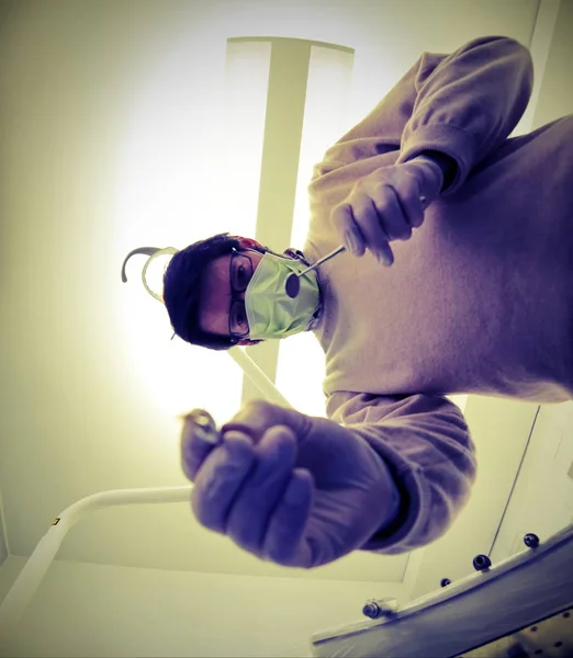 Doktor s nástroji v rukou v místnosti se svítilnou pro chirurgické ope — Stock fotografie