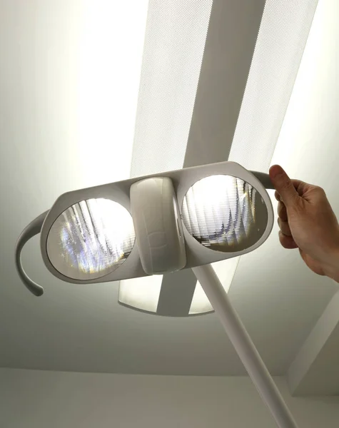 Hand of a dentist who directs the light before surgery in the me — Stock Photo, Image