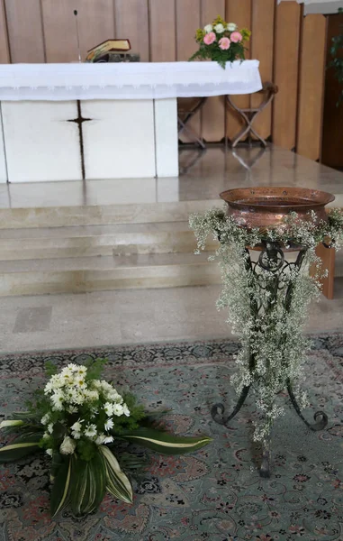 Altare bianco della chiesa cristiana con il fonte battesimale duri — Foto Stock