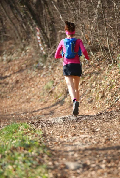 Kvinnan går snabbt med sport kostym i den mountain trail i win — Stockfoto
