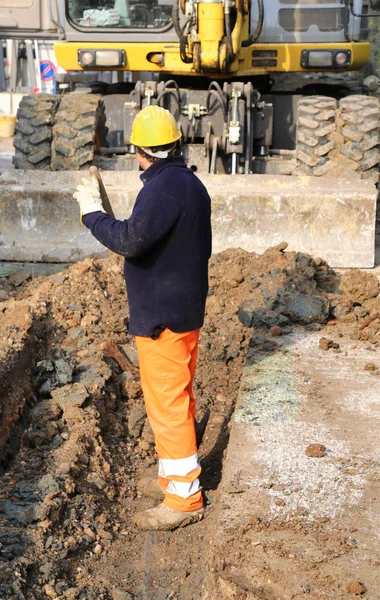 Man op het werk binnen de gracht en de bulldozer — Stockfoto
