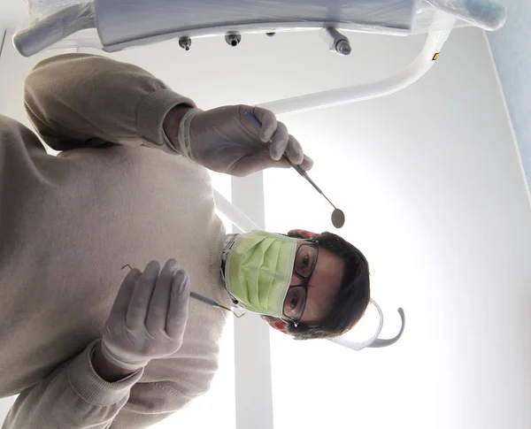 Persona con máscara y herramientas para la limpieza oral en un estudio dental —  Fotos de Stock