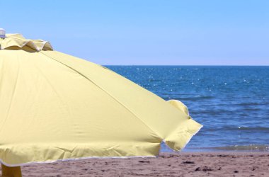 sarı güneş şemsiyesi sıcak yaz aylarında okyanusun kıyısında 