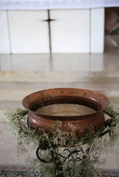 Fonte baptismal em cobre decorado com flores durante a relíquia — Fotografia de Stock