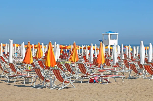 Geschlossene Sonnenschirme und Liegestühle am luxuriösen Sandstrand — Stockfoto