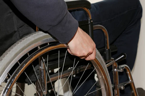 Hand op de rolstoel in de slaapkamer van de gehandicapte man — Stockfoto