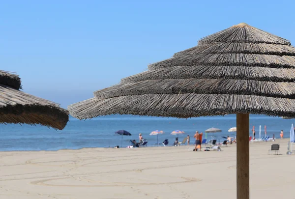 Strohsonnenschirm zum Schutz vor der heißen Sommersonne in der Bea — Stockfoto