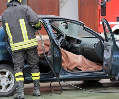 İtfaiye ekibi arabanın, yanında bir yol sonra yaralı adam çeker bir