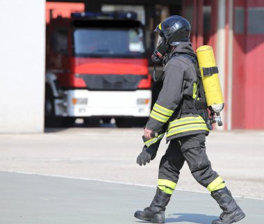 İtfaiyeci büyük oksijen silindir ve otomatik gaz maskesi ile