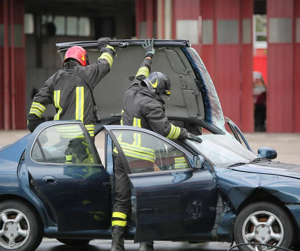 Strażak zespół startuje na dachu samochodu do ciągnięcia rany — Zdjęcie stockowe