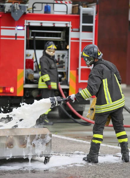 Firefighter training and fire extinguishing with foam and truck — Stock Photo, Image