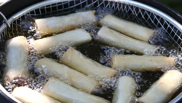 Pot avec de l'huile chaude pendant la cuisson en faisant frire les rouleaux de printemps — Photo