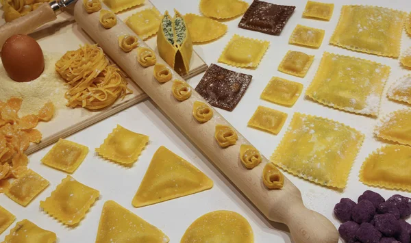 Pasta of many sizes with wooden rolling pin and tortellini and r — Stock Photo, Image