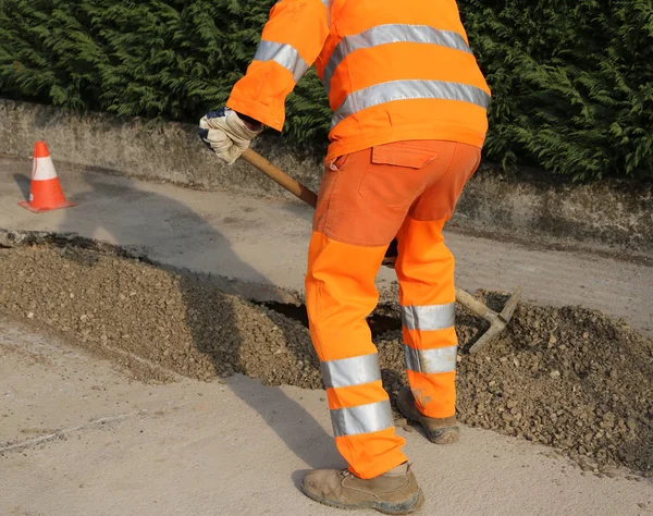 Travailleur avec des vêtements de haute visibilité tout en travaillant sur une con de route — Photo