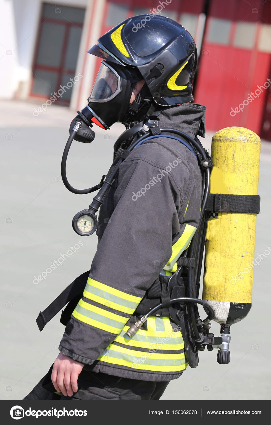 Firefighter with large yellow oxygen cylinder and protective hel — Stock  Photo © ChiccoDodiFC #156062078