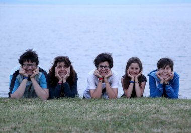 Plajda üç gülümseyen çocuklu aile