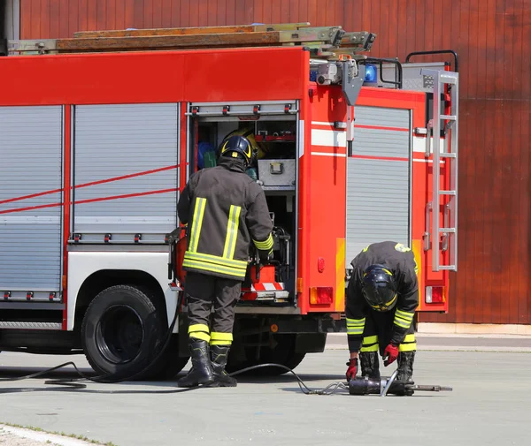 Fire trucks and firefighters with uniforms and protective helmet — Stock Photo, Image