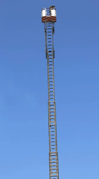 Корзина с воздушной платформой над очень длинной специальной лестницей — стоковое фото