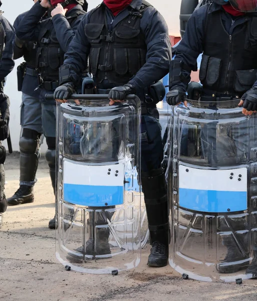 Gruppe von Bereitschaftspolizisten mit Schlagstöcken und Schutzschilden während der Sicherheitskontrolle — Stockfoto