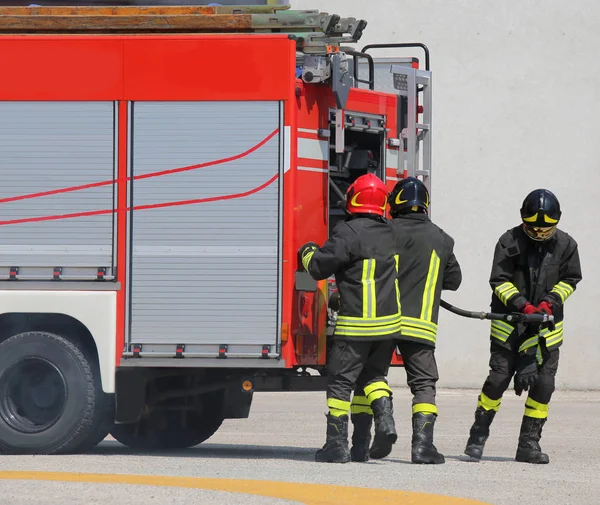 Camiones de bomberos y bomberos con uniformes — Foto de Stock
