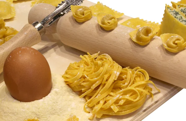 新鲜的意大利面食的许多大小与木擀面杖和饺子 — 图库照片