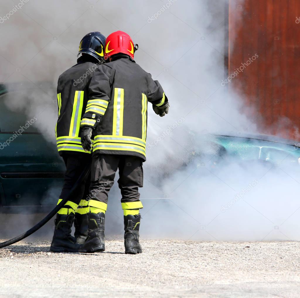 firefighters with uniform and protective helmet extinguish the f