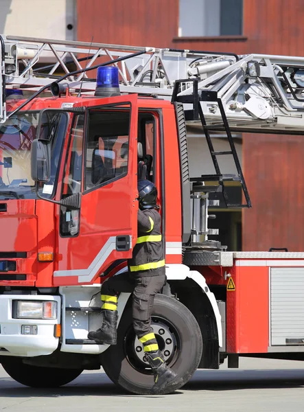 Firefighter drops fast from the fire truck during firefighting — Stock Photo, Image