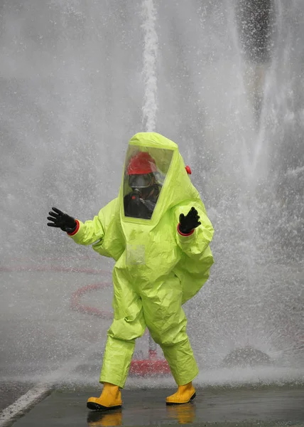 Hombre con traje protector amarillo contra agentes químicos y spl — Foto de Stock