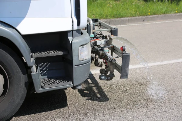 Respingo de água de caminhão para lavar as estradas urbanas — Fotografia de Stock