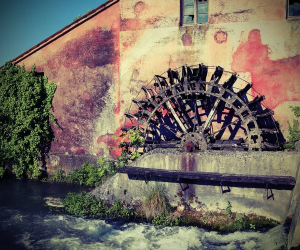 Grande roda de um moinho de água abandonado com efeito vintage — Fotografia de Stock