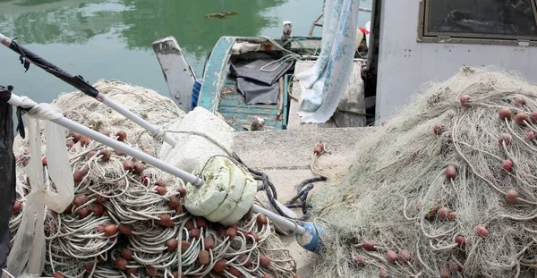 Barco de pesca com muitas redes de pesca ancoradas na pequena marina — Fotografia de Stock