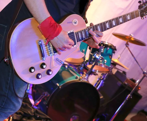 Guitarist plays electric guitar on stage during a live concert — Stock Photo, Image