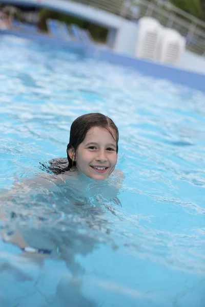 Jeune fille apprend à nager dans la piscine — Photo