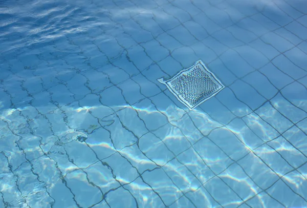 Agua clara de la piscina y parrilla metálica para recirculación y purificación —  Fotos de Stock
