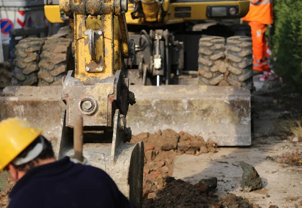 Sitio de construcción con la excavadora y el trabajador dentro de la excavación — Foto de Stock