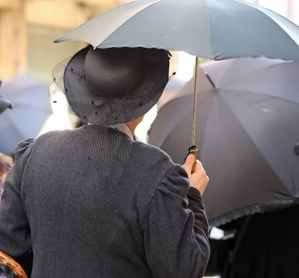 Ältere Dame mit Vintage-Kleidung und schwarzem Regenschirm mit Vint — Stockfoto