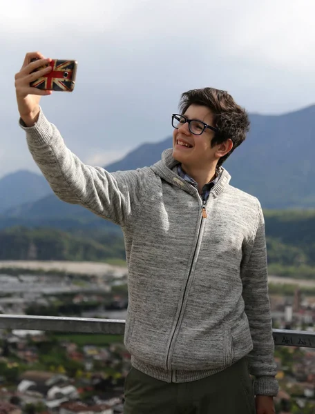 Белый улыбающийся мальчик с современным смартфоном — стоковое фото